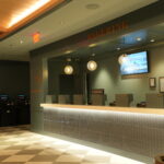 Casino counter with glass globe pendant lights and row of betting kiosks; 'WAGERING' sign above the counter.