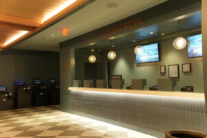 Casino counter with glass globe pendant lights and row of betting kiosks; 'WAGERING' sign above the counter.