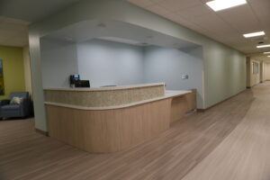 Reception desk in a modern hallway with light blue walls and wood flooring