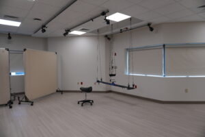 Rehabilitation studio with ceiling-mounted suspension track and harness system in an empty room.